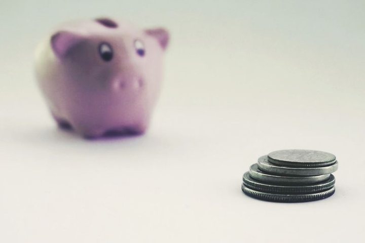 豚の貯金箱と、積んだ硬貨
